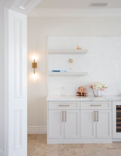 A bright, modern kitchen corner with white cabinetry, subway tile backsplash, and marble countertop.