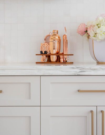 Elegant kitchen countertop with copper accessories and a bouquet of flowers.