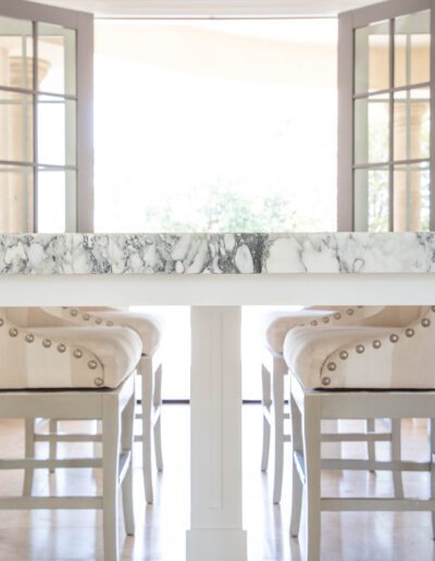 Elegant kitchen interior with a marble counter and bar stools.