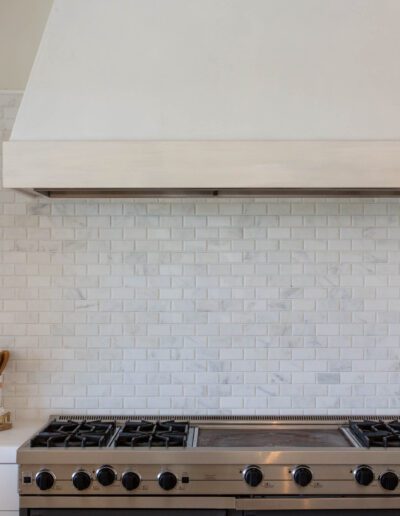 Modern kitchen with stainless steel stove and white subway tile backsplash.