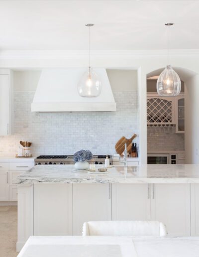 Modern kitchen interior with white cabinetry and stainless steel appliances.