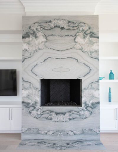 Elegant living room with a white marble fireplace and built-in cabinetry.